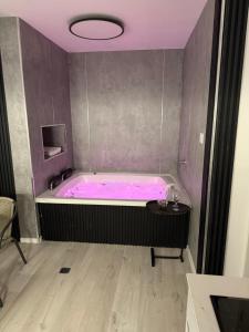 a pink bath tub in a room with a table at חוויה בכיכר in Netanya