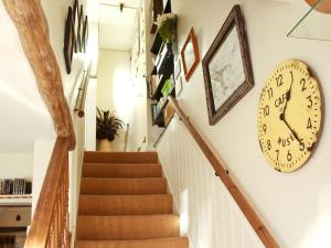 a stairway with a clock on the wall and a staircase at Tanner's Cottage in Cockermouth +5 photos