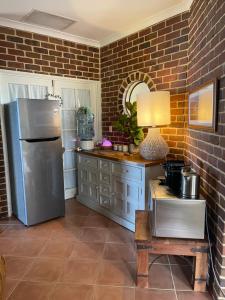 a kitchen with a stainless steel refrigerator and a table at Blue Haven Beach House - Guest Suite I 