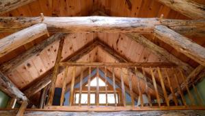 ein Dach eines Holzgebäudes mit einem Fenster in der Unterkunft Cozy Lakefront Cabin Rental in the Woodlands of Empire, Michigan in Maple City + 17 Fotos