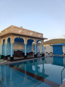 a pool at a resort with chairs and a building at Aryavarta A Boutique Abode in Nāi