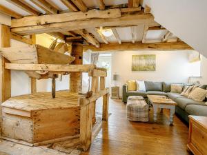a living room with a couch and a room with wooden ceilings at The Water Mill in Bradbourne