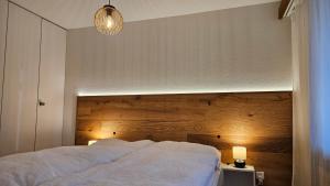 a bedroom with a large bed with a wooden headboard at Sonnenzauber in Andermatt