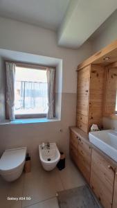 une salle de bain avec un lavabo et des toilettes et une fenêtre dans l'établissement Olimpic games Cortina, à San Candido