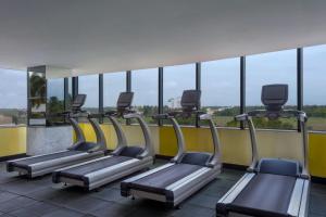 哥印拜陀哥印拜陀艾美度假酒店的带窗户的健身房里有一排跑步机