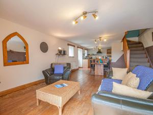 a living room with a couch and chairs and a table at Cwm Nantcol Barn in Llanbedr