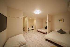 a hotel room with two beds and a table at YUFU-Inn プライベートな露天風呂付き-由布院駅徒歩2分 in Yufuin