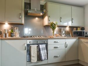 a kitchen with white cabinets and a stove at Hornby Cottage in Saint Michaels on Wyre
