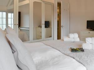 a bedroom with a large white bed and a mirror at The Orangery in Bideford +6 photos
