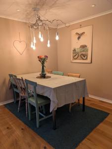 a dining room table with chairs and a vase of flowers at Home in Vingåker in Vingåker