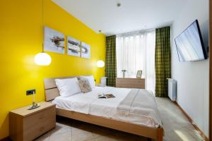 ein Schlafzimmer mit einem Bett mit gelber Wand in der Unterkunft Yerevan Elite Stay - Republic Square in Yerevan