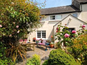 a garden with a table and chairs in front of a house at Llys Isaf in Saint Nicholas +16 photos