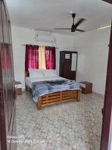 1 dormitorio con 1 cama grande y ventana roja en New Paradise Inn, en Varkala