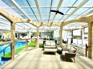 un bâtiment avec une véranda équipée de chaises et d'un plafond dans l'établissement וילות היוקרה עידן הנוף ואחוזת אסתובן, à Ya‘ara