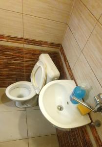 un baño con inodoro y lavabo en shared rooms, en Pristina