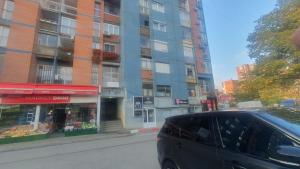 una furgoneta negra estacionada frente a un edificio en shared rooms, en Pristina