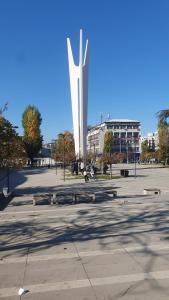 una gran estatua en medio de un estacionamiento en shared rooms, en Pristina 11 fotos más
