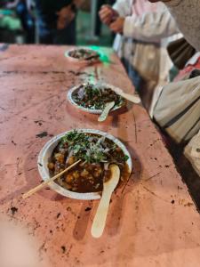 two bowls of food on a wooden table at Hammock Hostels - Jaipur in Jaipur