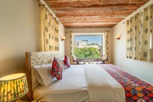 a bedroom with a bed and a window at The Munshi Mansion in Jodhpur