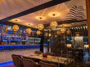 a restaurant with a long table and a bar at Gooseberry Baan & Bistro in Pattaya South