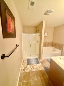 a bathroom with a shower and a sink and a tub at Your Lawrenceville home in the heart of it all in Lawrenceville