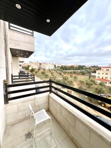 a white chair sitting on the balcony of a building at Ammon Sun Residence in Amman