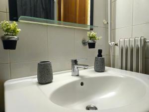 Un lavabo de baño con dos jarrones encima. en Calliope's Home, en Tríkala