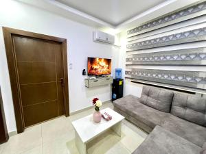 a living room with a couch and a fireplace at Ammon Sun Residence in Amman