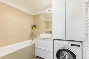 ブラチスラヴァにあるBALRENT Slovakia Ovocné sady Airport Apartmentの洗濯機と乾燥機を備えたランドリールーム