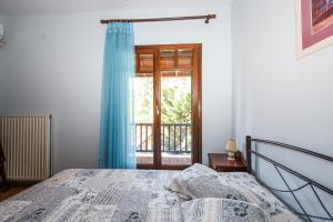 een slaapkamer met een bed met een blauw gordijn en een raam bij Asano's House in Agios Nikolaos