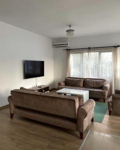 sala de estar con sofá grande y TV en RIX Apartments, en Kyrenia