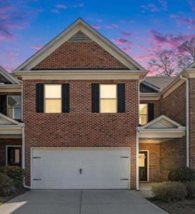 a large brick house with a white garage at Your Lawrenceville home in the heart of it all in Lawrenceville