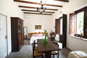1 dormitorio con mesa y 1 cama en una habitación en Agriturismo Gli Aranci dell'Etna, en Mascali