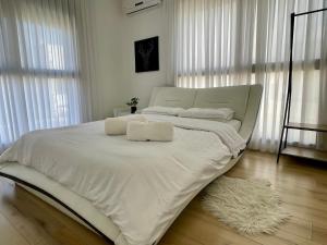 Una cama blanca con dos toallas encima. en הבית בחוף הזהב, en Cesarea 7 fotos más