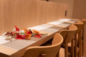 a long table with chairs and flowers on it at Authentic Kyoto Machiya Sleeps 7 Near Station in Fushimi