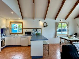 a kitchen with white cabinets and a blue counter top at Dunes Blue at Robe in Robe