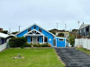 a blue house with a green lawn in front of it at Dunes Blue at Robe in Robe