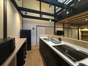 a large kitchen with a sink and a counter at Authentic Kyoto Machiya Sleeps 7 Near Station in Fushimi