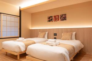 two beds in a room with at Authentic Kyoto Machiya Sleeps 7 Near Station in Fushimi +49 photos