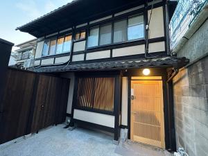 a house with a yellow door in front of it at Authentic Kyoto Machiya Sleeps 7 Near Station in Fushimi
