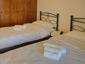 Dos camas en una habitación con toallas encima. en Calliope's Home, en Tríkala