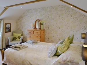 a bedroom with a bed and a mirror and a chair at Gwel An Porth in Charlestown