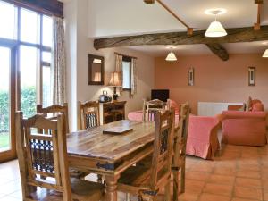 Un comedor con mesa y sillas de madera. en Sorrel - E4321, en Ludham