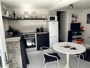a small kitchen with a table and a table and chairs at la cachette bas in Salies-de-Béarn