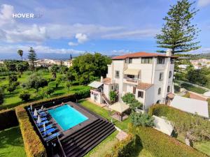 an aerial view of a house with a swimming pool at John Sea Suites in Giardini Naxos