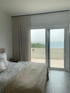 ein Schlafzimmer mit Bett und Blick auf den Strand in der Unterkunft Villa Rocky Beach in Ražanac