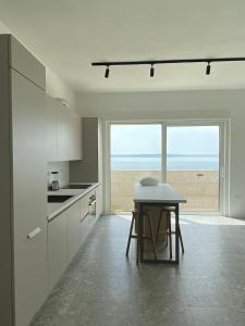 eine Küche mit Tisch und Blick auf das Meer in der Unterkunft Villa Rocky Beach in Ražanac
