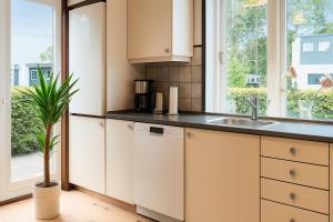 a kitchen with white cabinets and a potted plant at Strandhuset i Øster Hurup in Øster Hurup