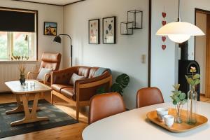 a living room with a couch and a table at Strandhuset i Øster Hurup in Øster Hurup