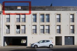 a white car parked in front of a building at Cenon plein ciel in Cenon